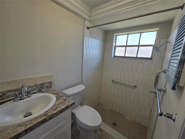 a bathroom with a granite countertop sink toilet and shower