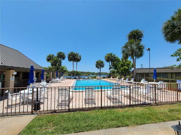 a view of a house with backyard swimming pool and sitting area