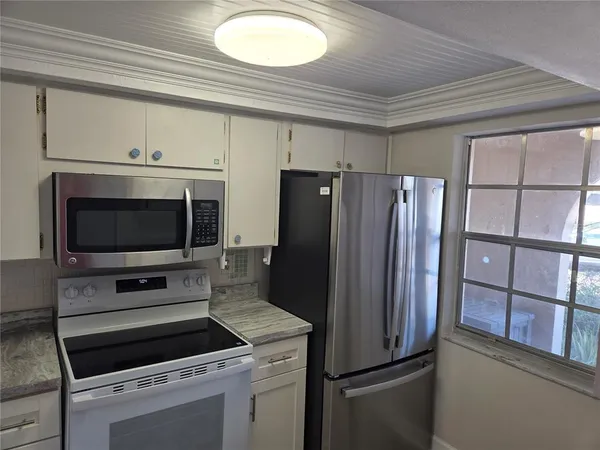 a kitchen with stainless steel appliances a refrigerator stove and microwave