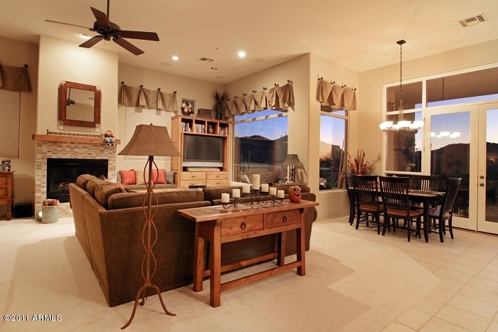 11059 East Turnberry Road Scottsdale, AZ 85255 - Photo 16 of 35 a living room with furniture a fireplace and a chandelier