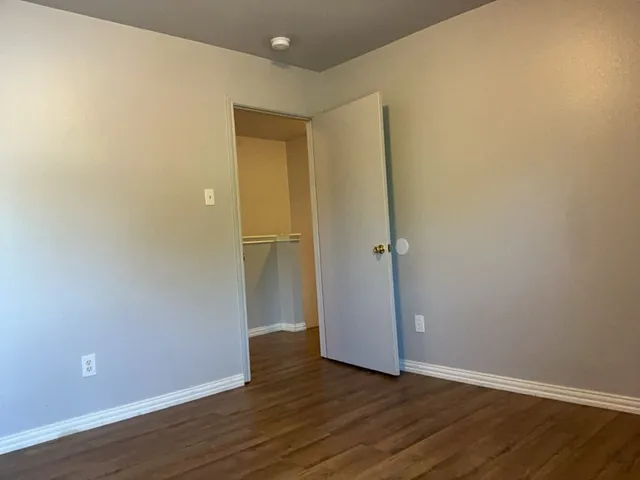 an empty room with wooden floor and closet