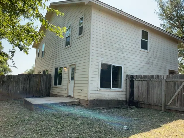a view of a house with a yard and wooden fence