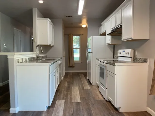 a kitchen with stainless steel appliances a white stove top oven and a refrigerator