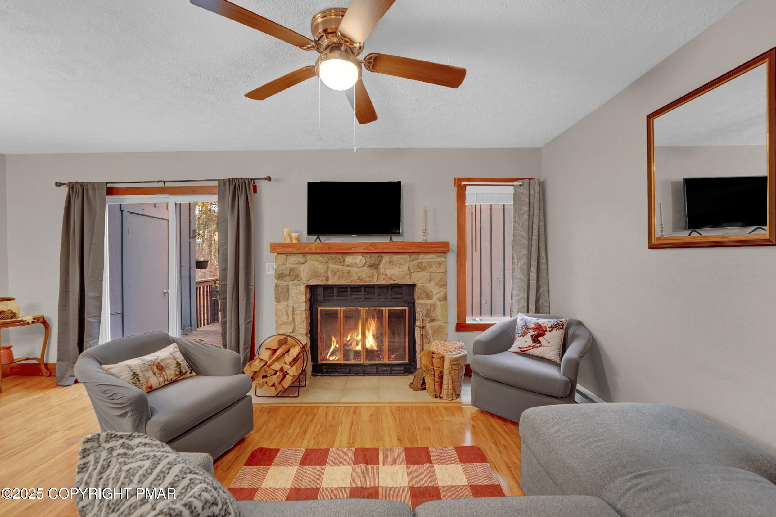 a living room with furniture a flat screen tv and a fireplace