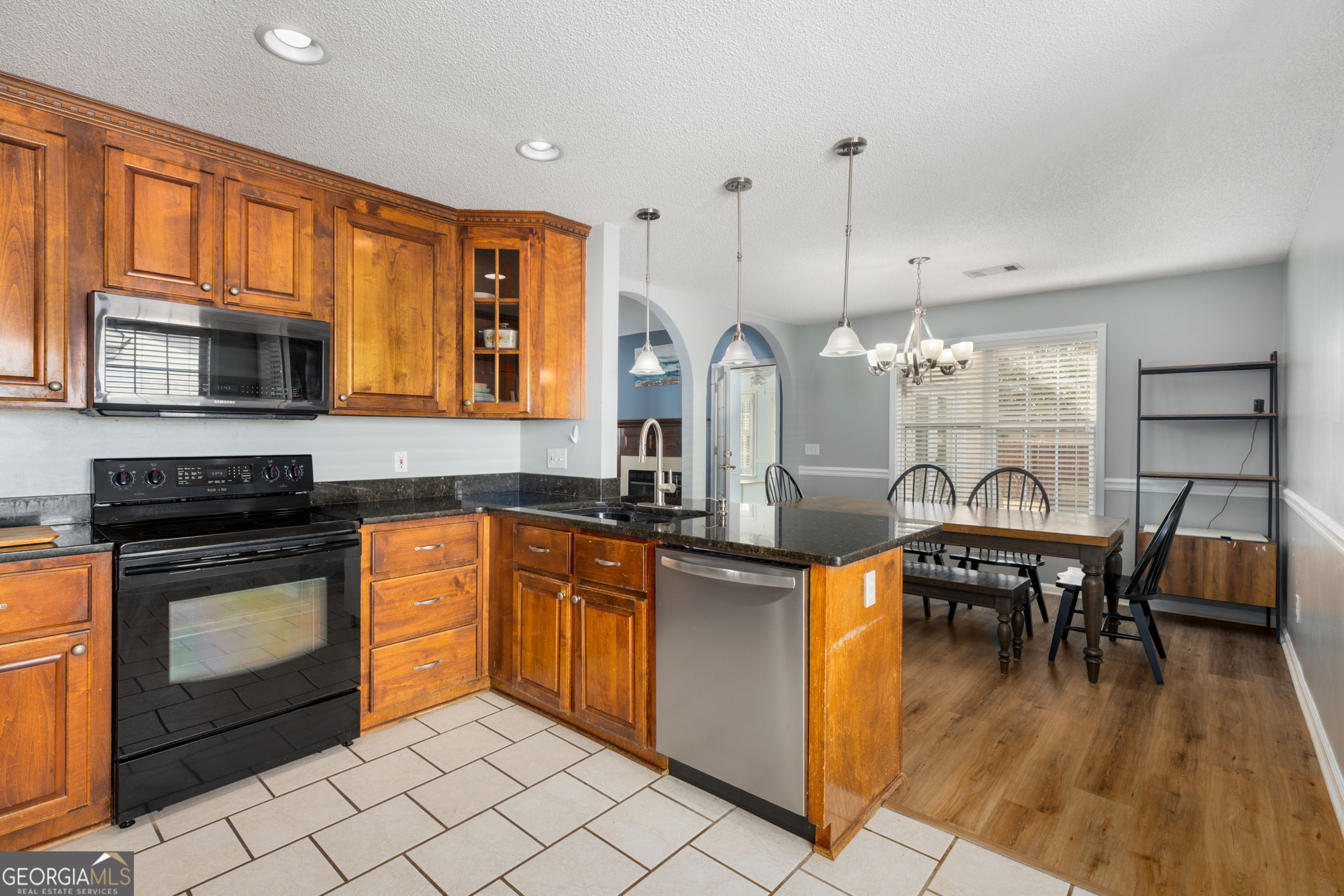 113 Hummingbird Lane Kathleen, GA 31047 - Photo 27 of 44 a kitchen with stainless steel appliances granite countertop a stove a sink dishwasher a dining table and chairs with wooden floor