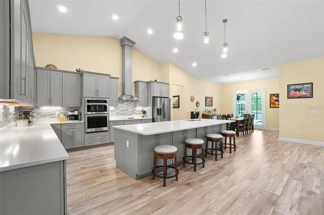 a large kitchen with stainless steel appliances a large counter top a sink a stove and a refrigerator