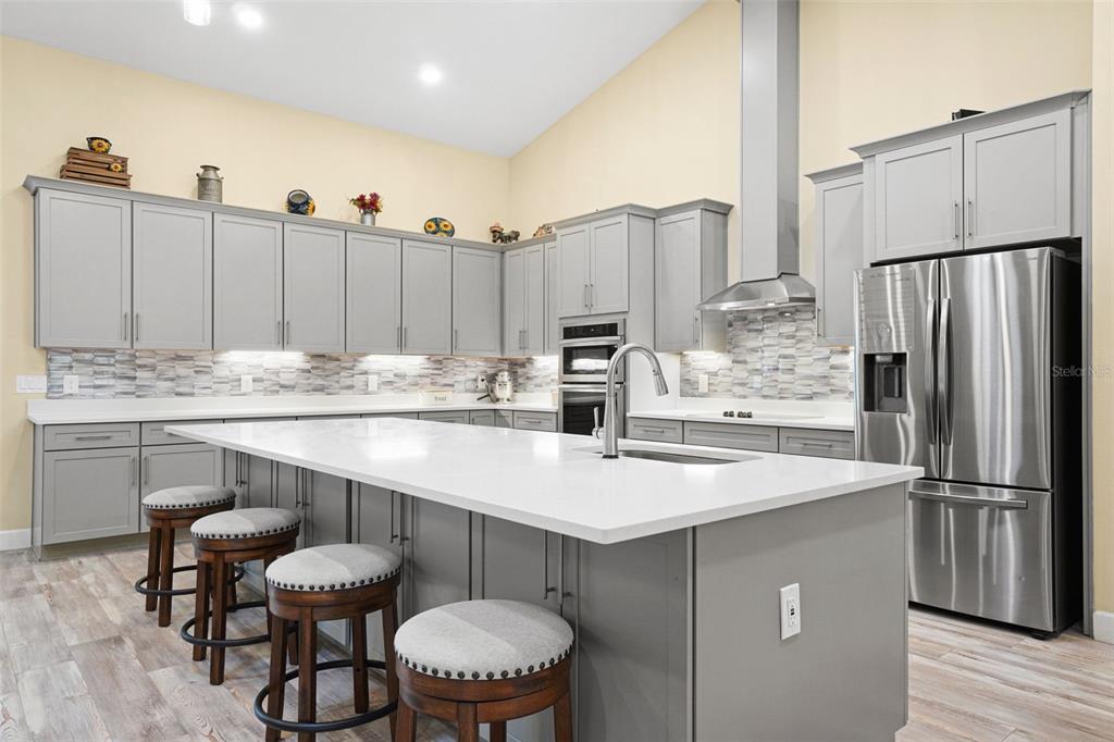 3230 Pheasant Trail Mims, FL 32754 - Photo 13 of 71 a kitchen with stainless steel appliances kitchen island granite countertop a table chairs and a refrigerator