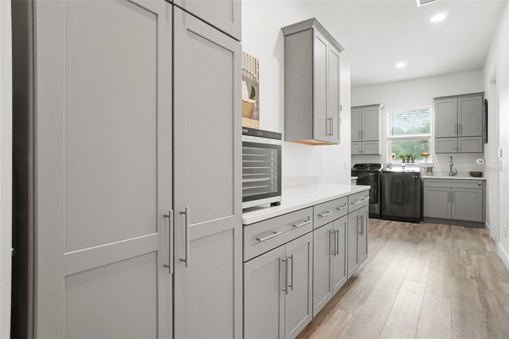 3230 Pheasant Trail Mims, FL 32754 - Photo 18 of 71 a kitchen with stainless steel appliances white cabinets and wooden floors
