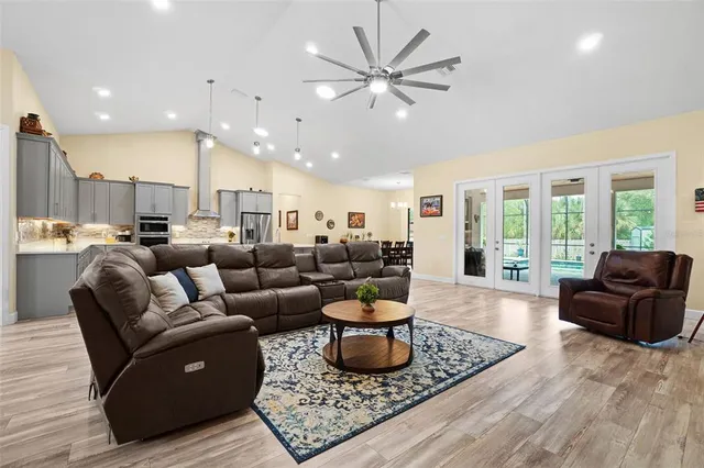 a kitchen with stainless steel appliances kitchen island granite countertop a table chairs and a refrigerator
