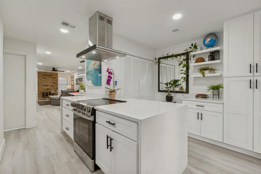 10635 Stone Canyon Road, Unit 19 Dallas, TX 75230 - Photo 12 of 25 a kitchen with granite countertop a white stove top oven and white cabinets with wooden floor