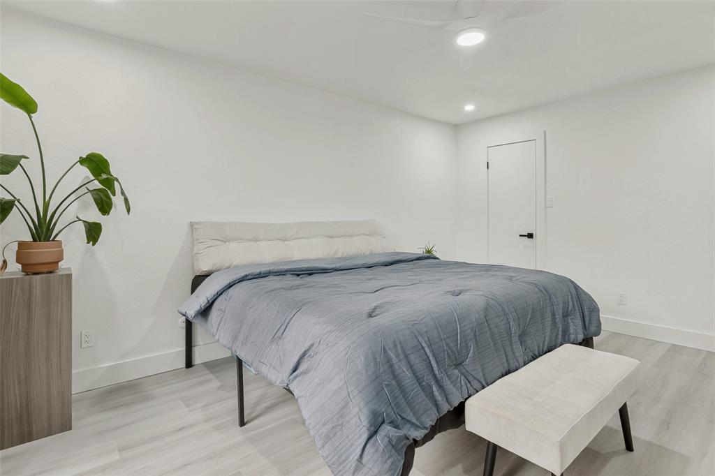 10635 Stone Canyon Road, Unit 19 Dallas, TX 75230 - Photo 19 of 25 a bedroom with a bed and a potted plant