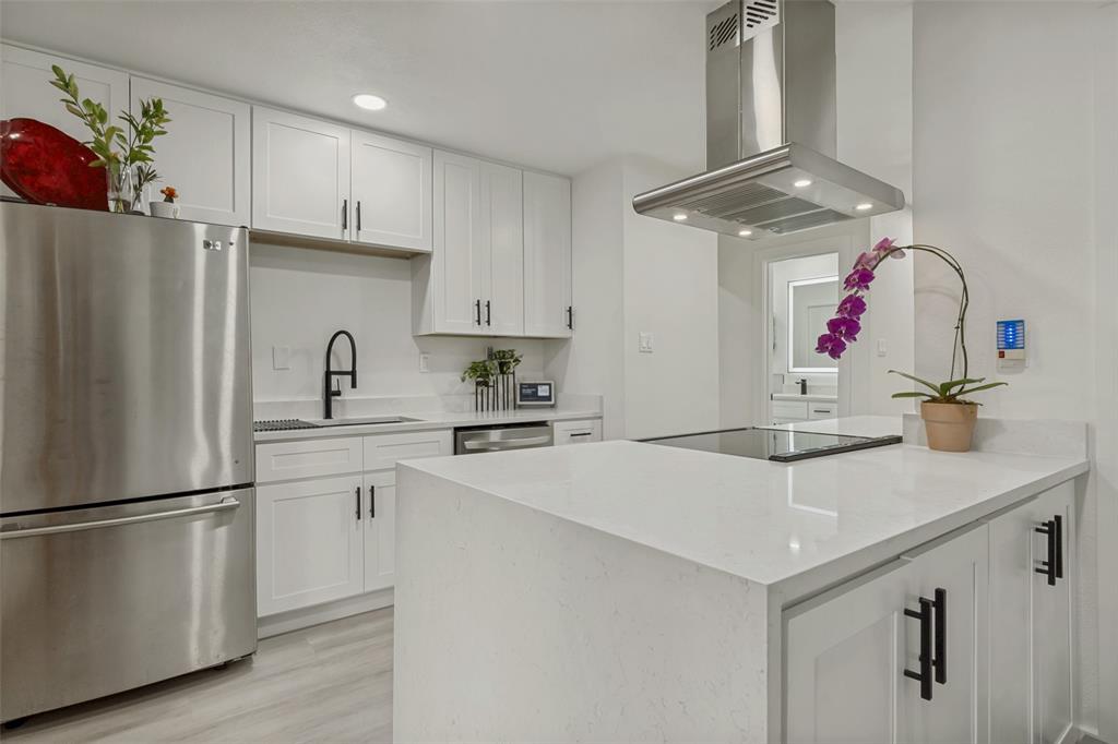 10635 Stone Canyon Road, Unit 19 Dallas, TX 75230 - Photo 10 of 25 a kitchen with a sink a refrigerator and white cabinets