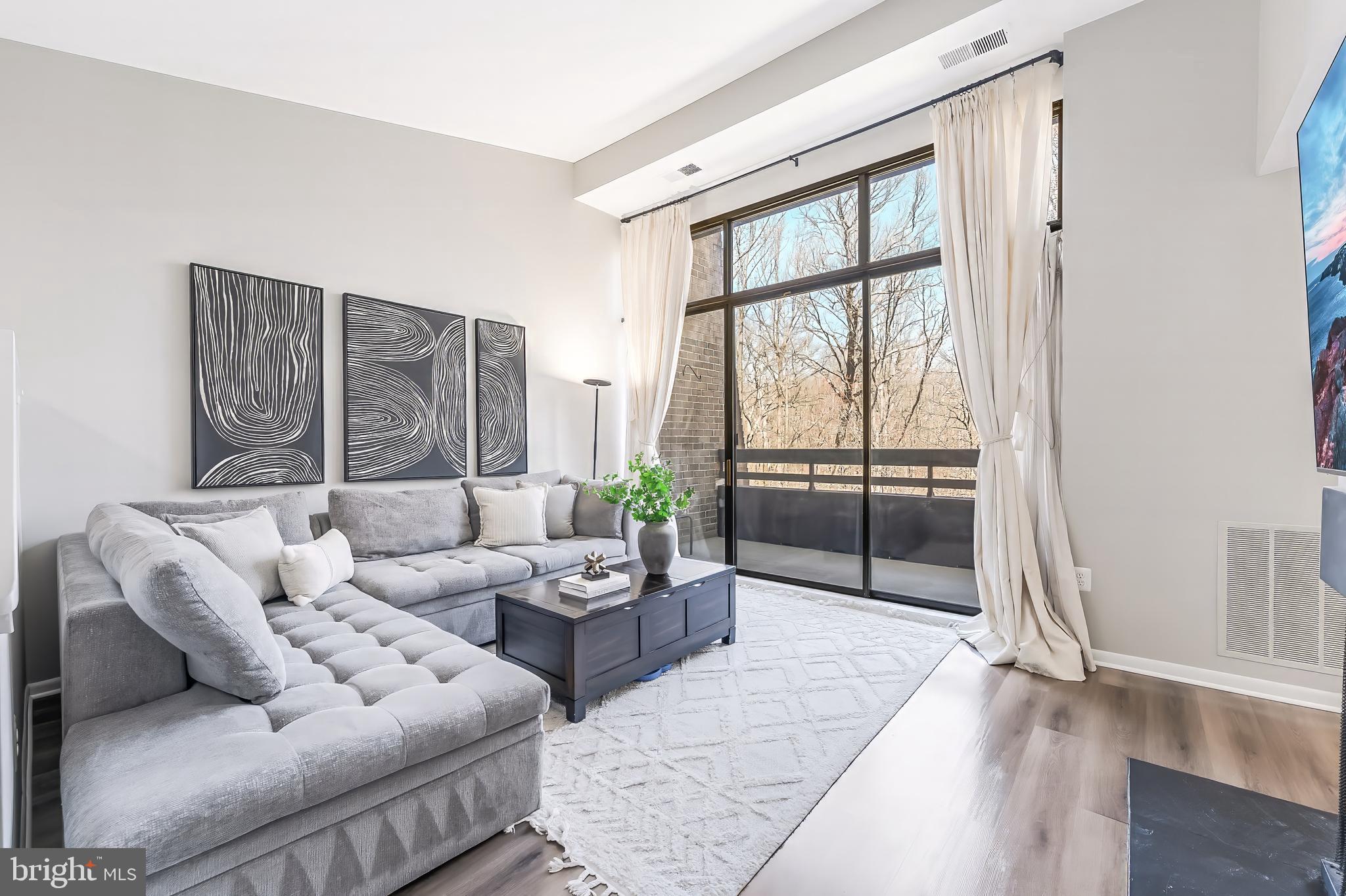 11564 Rolling Green Court, Unit 12/301B Reston, VA 20191 - Photo 14 of 31 a living room with furniture and a large window