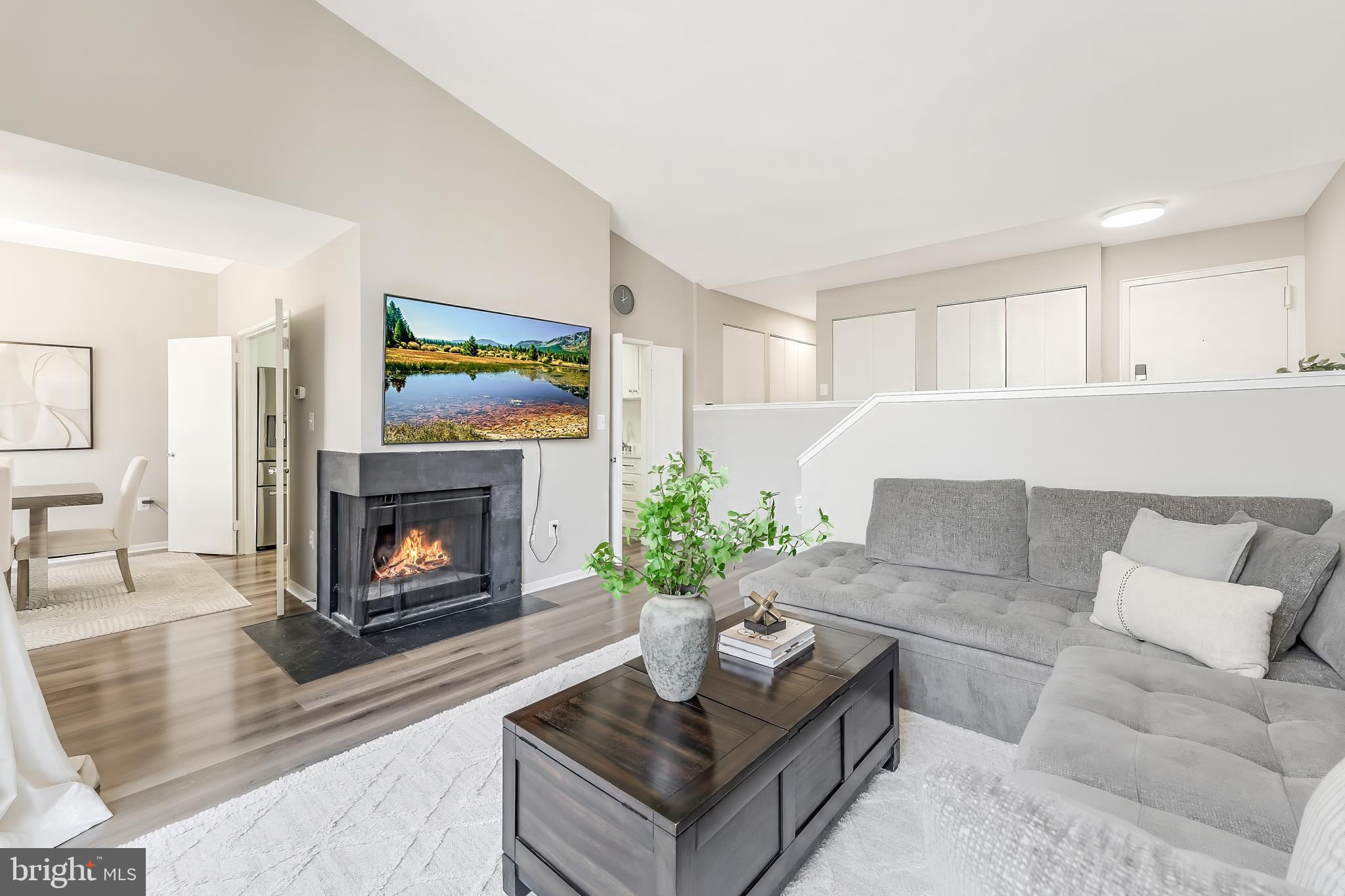 11564 Rolling Green Court, Unit 12/301B Reston, VA 20191 - Photo 15 of 31 a living room with furniture a fireplace and a painting
