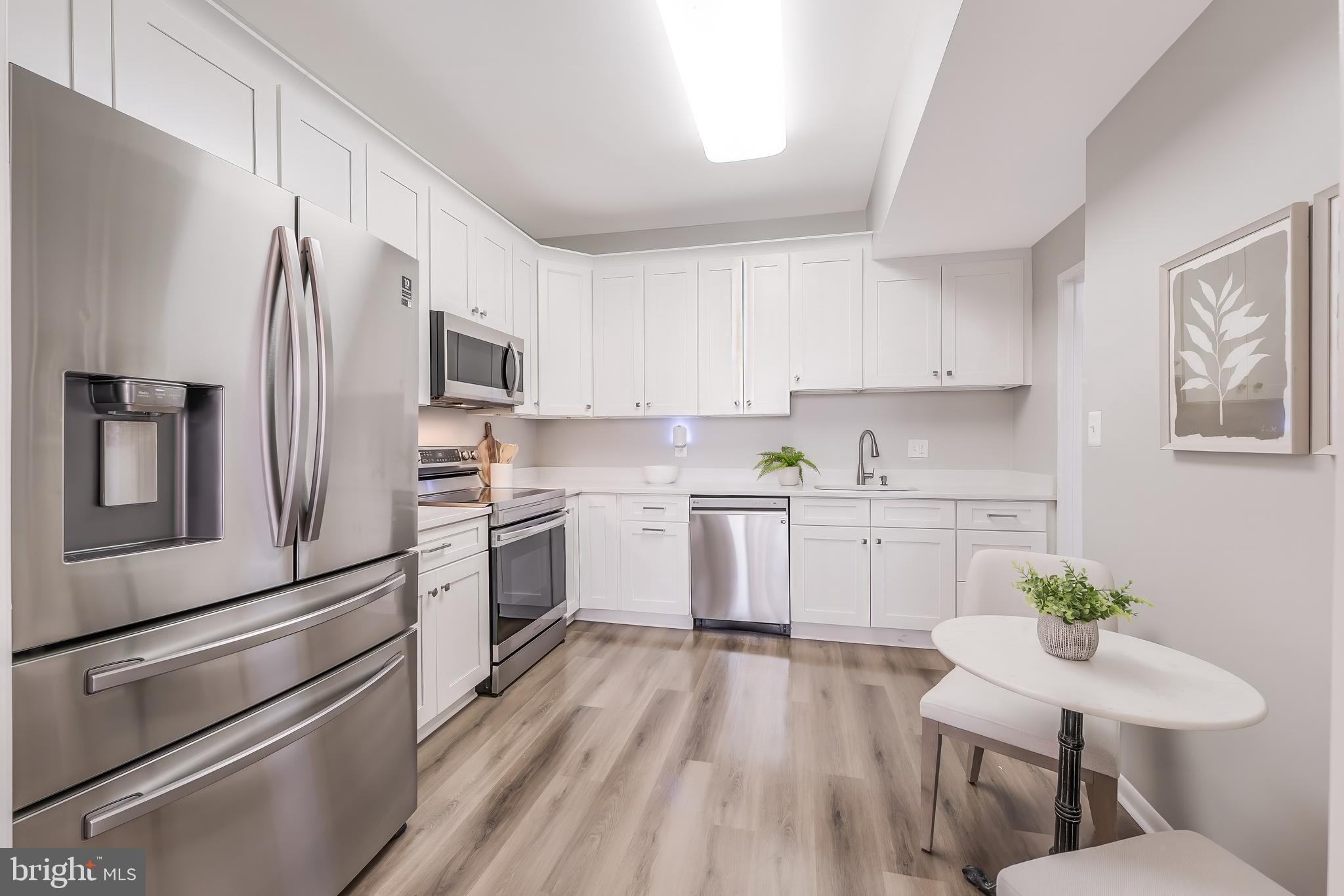 11564 Rolling Green Court, Unit 12/301B Reston, VA 20191 - Photo 2 of 31 a kitchen with white cabinets stainless steel appliances and white cabinets