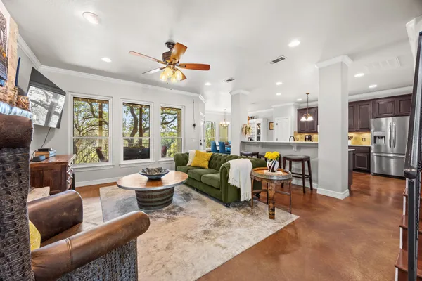 a living room with furniture kitchen view and a large window