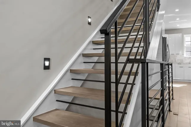 a kitchen with kitchen island a refrigerator a stove a sink and a island with wooden floor