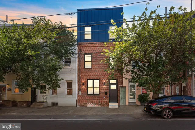 a view of a building and car parked on the road