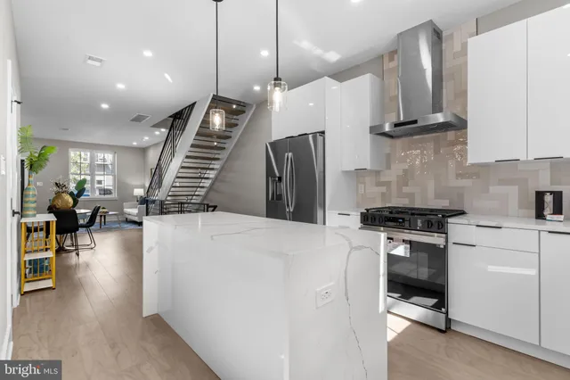 a kitchen with stainless steel appliances white cabinets and a stove top oven