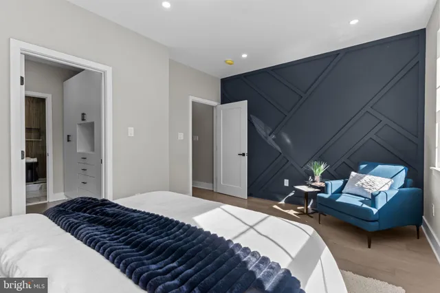 a bedroom with a bed and a lamp on dresser