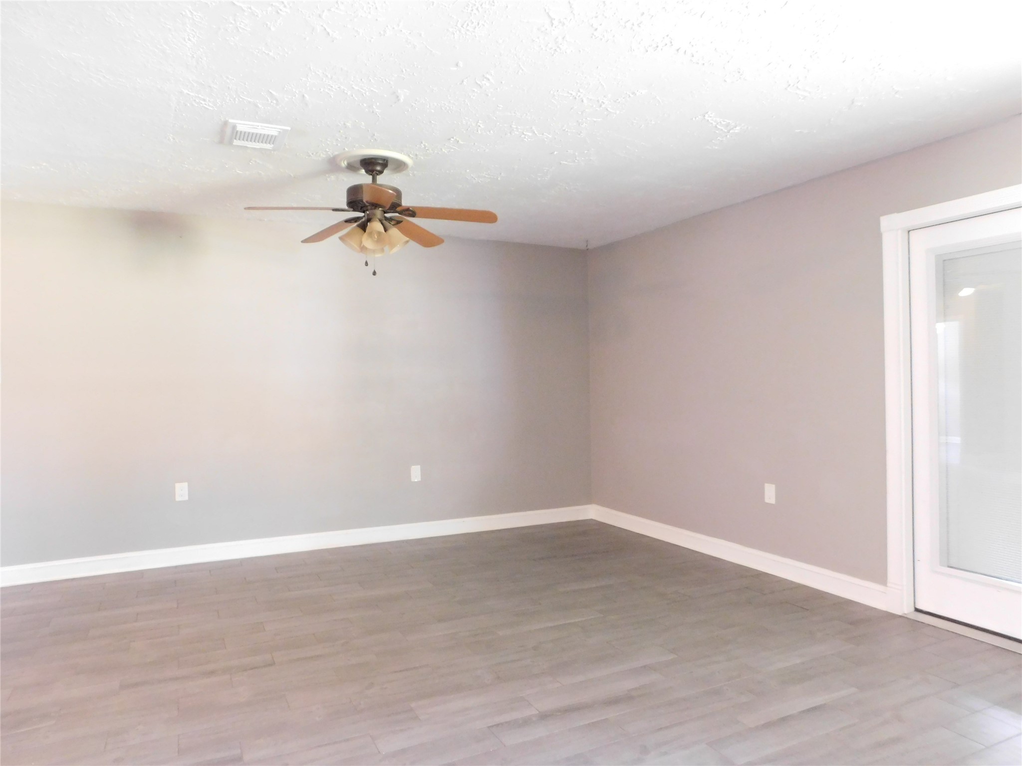 5003 Apple Springs Drive Pearland, TX 77584 - Photo 11 of 29 a view of a room with wooden floor and a ceiling fan