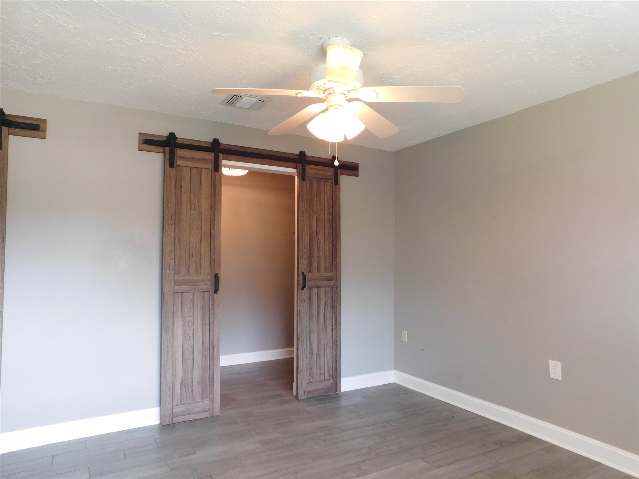 5003 Apple Springs Drive Pearland, TX 77584 - Photo 13 of 29 an empty room with wooden floor fan and windows