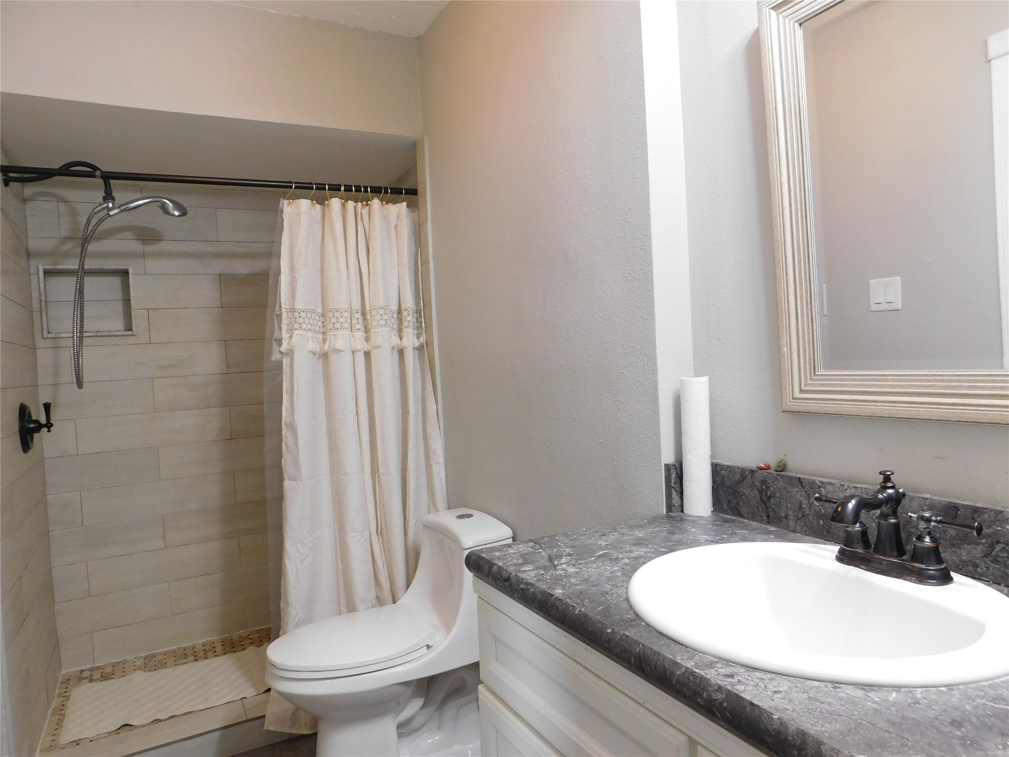 5003 Apple Springs Drive Pearland, TX 77584 - Photo 18 of 29 a bathroom with a granite countertop sink toilet a mirror and shower