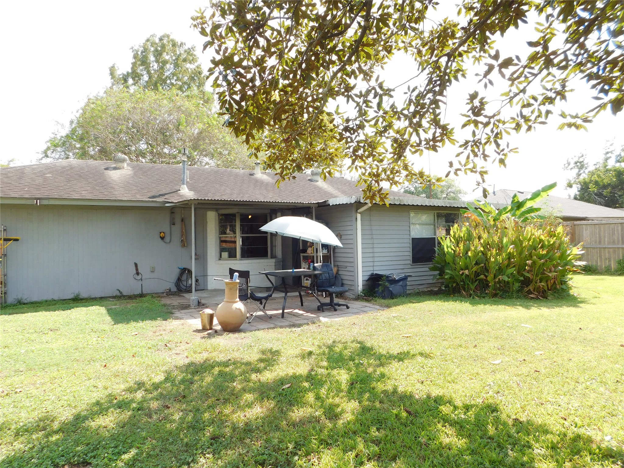 5003 Apple Springs Drive Pearland, TX 77584 - Photo 26 of 29 a backyard of a house with table and chairs under an umbrella