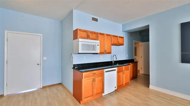 a kitchen with granite countertop a sink and a wooden floor