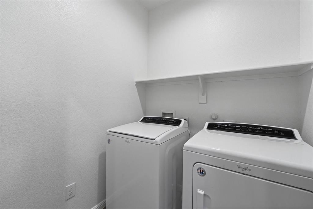 4600 Fringetree Way Crowley, TX 76036 - Photo 14 of 40 Dedicated laundry space featuring a white wall shelf, textured walls, and a white appliance set