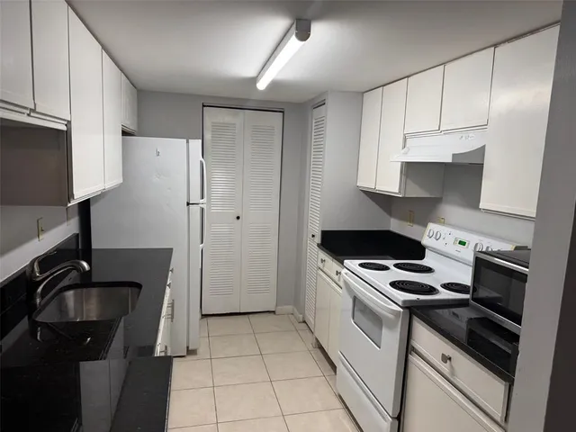 a kitchen with a sink appliances and cabinets