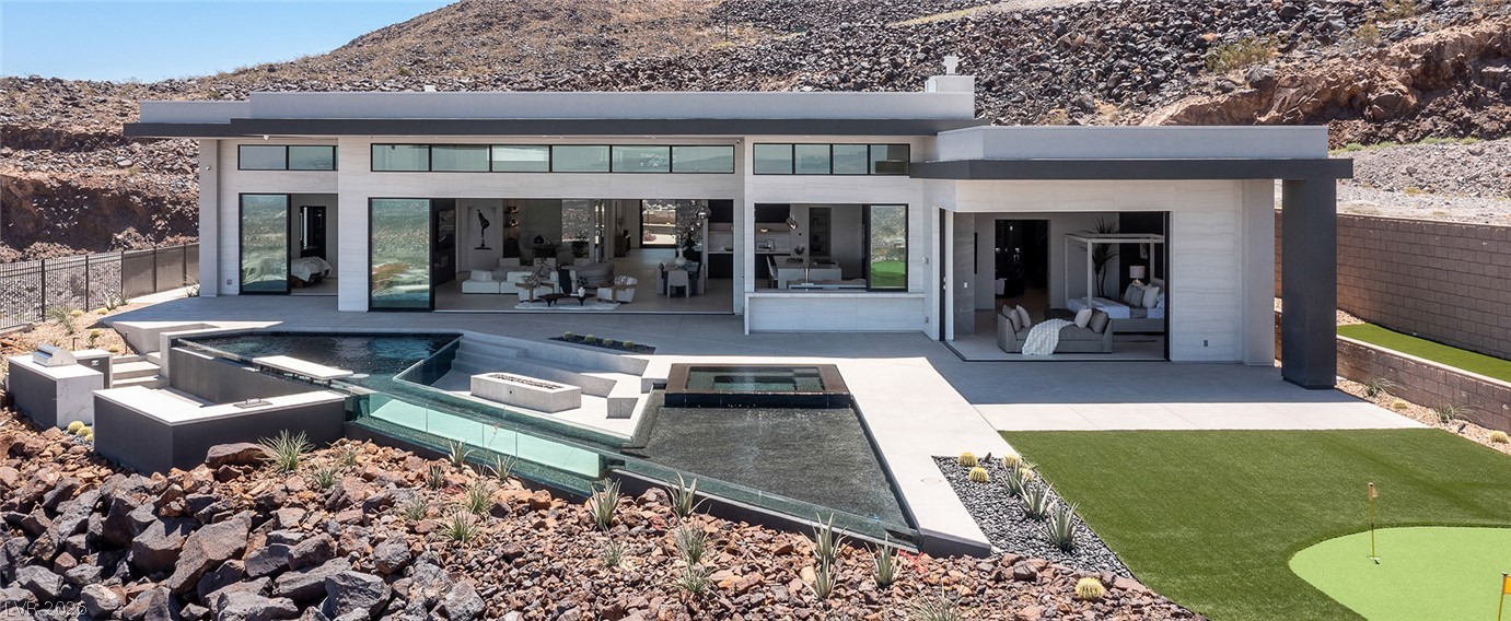 563 Grand Rim Drive Henderson, NV 89012 - Photo 62 of 70 Experience modern living with a desert backdrop, featuring a refreshing pool and putting green.