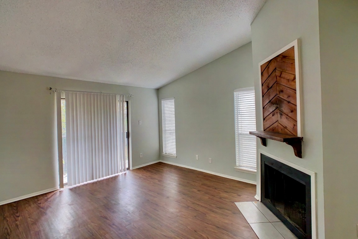 2008 West Loop, Unit D Austin, TX 78758 - Photo 4 of 15 a view of an empty room with wooden floor and a window