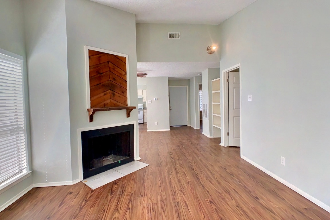2008 West Loop, Unit D Austin, TX 78758 - Photo 6 of 15 an empty room with wooden floor and fireplace