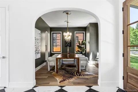 a dining room with furniture a potted plant and a chandelier