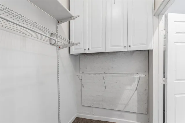 a view of walk in closet with empty racks