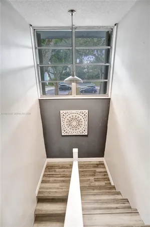 a living room with stainless steel appliances kitchen island granite countertop a stove a sink a dining table and chairs with wooden floor