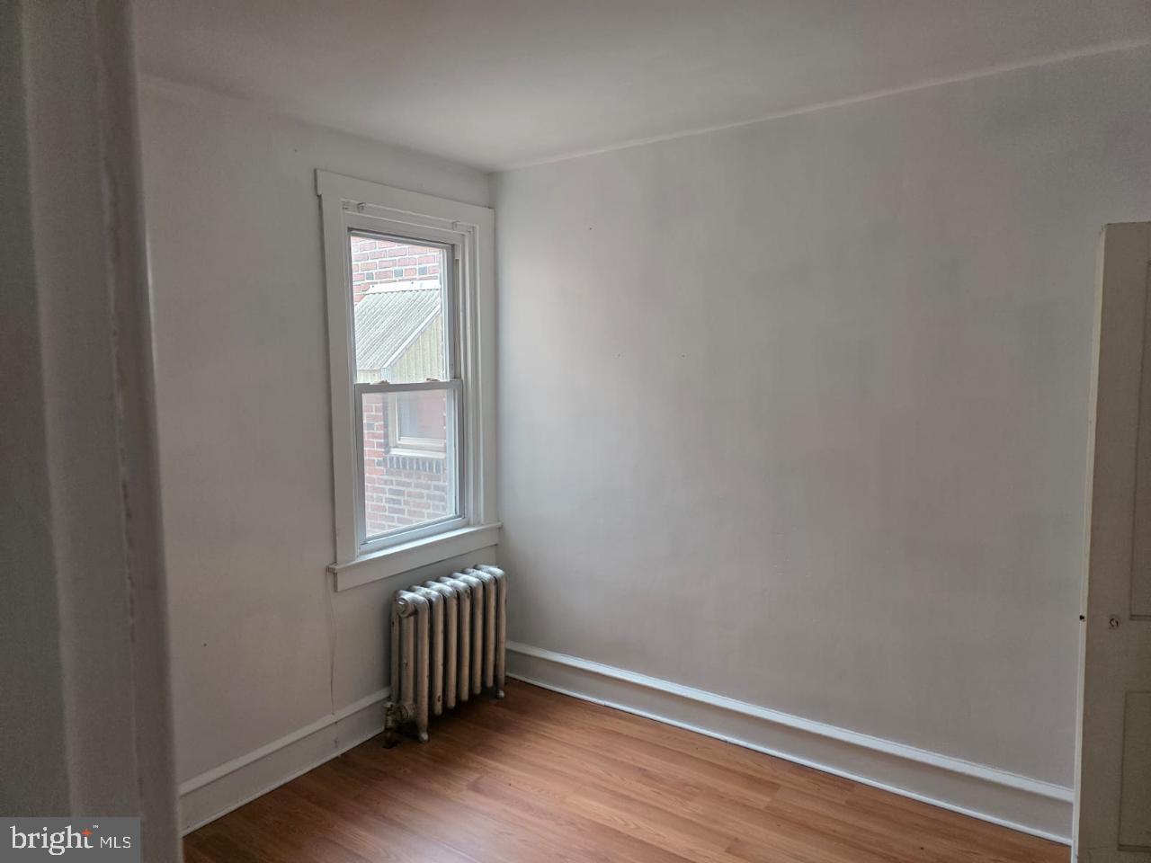 5805 North 15th Street Philadelphia, PA 19141 - Photo 12 of 12 a view of an empty room with wooden floor and a window