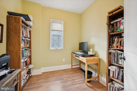 a view of a workspace with furniture and a bookshelf