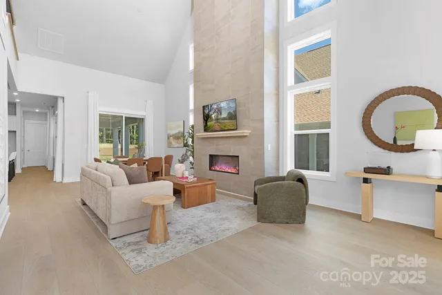 a living room with furniture a fireplace and a large window
