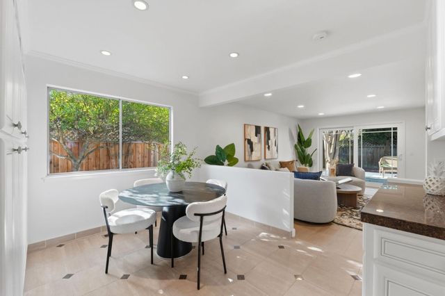 a dining room with furniture and a potted plant