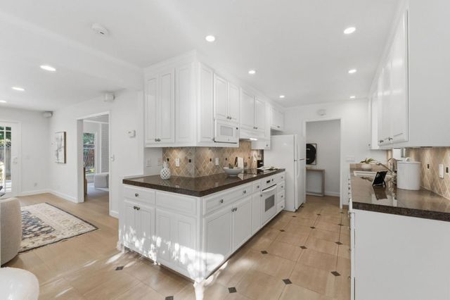 a room with a potted plant on the counter and cabinets