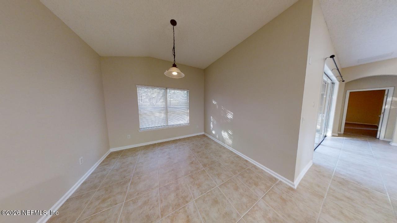 14454 Millhopper Road Jacksonville, FL 32258 - Photo 7 of 44 a view of an empty room with window and chandelier fan