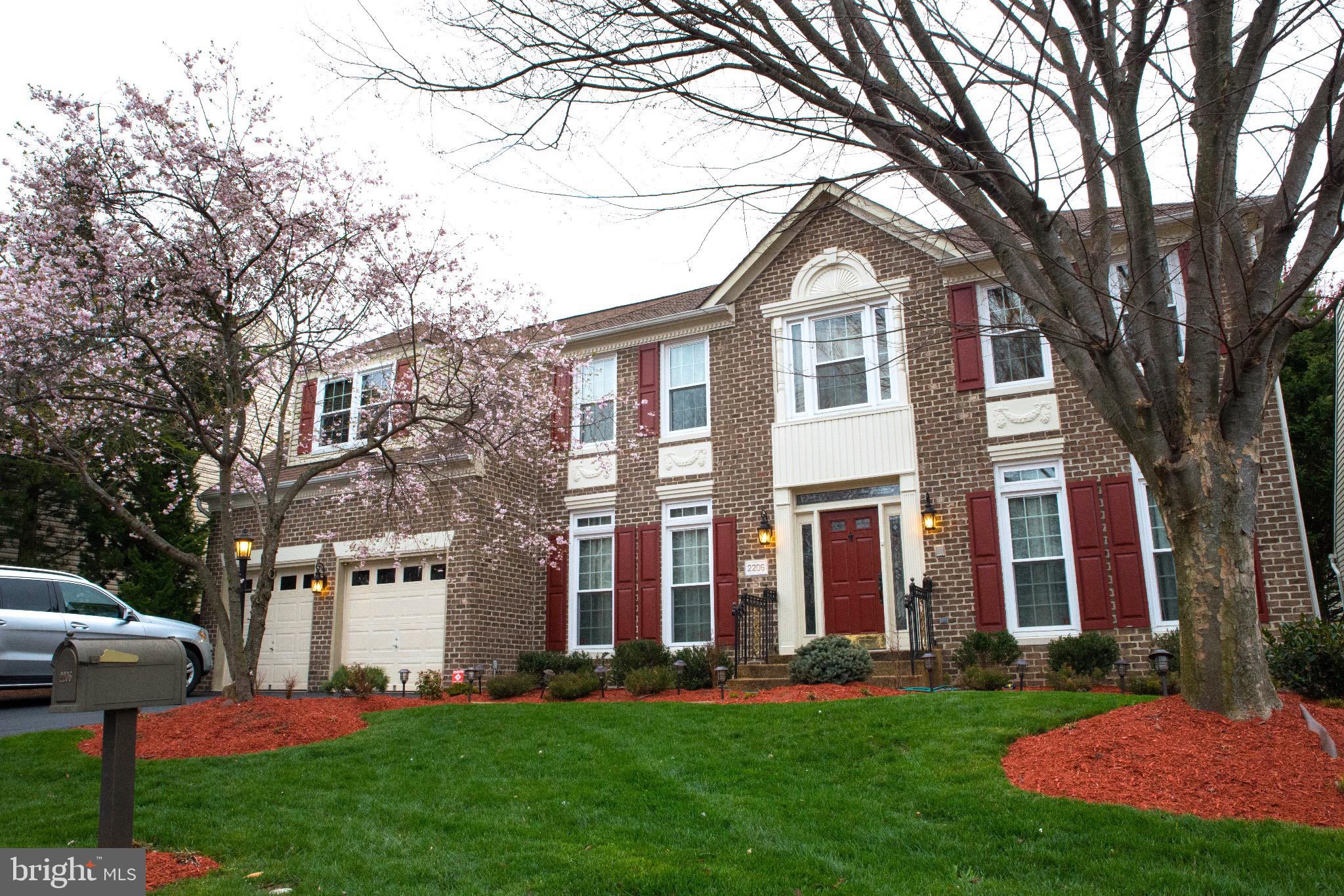 Charming brick home with blooming trees.