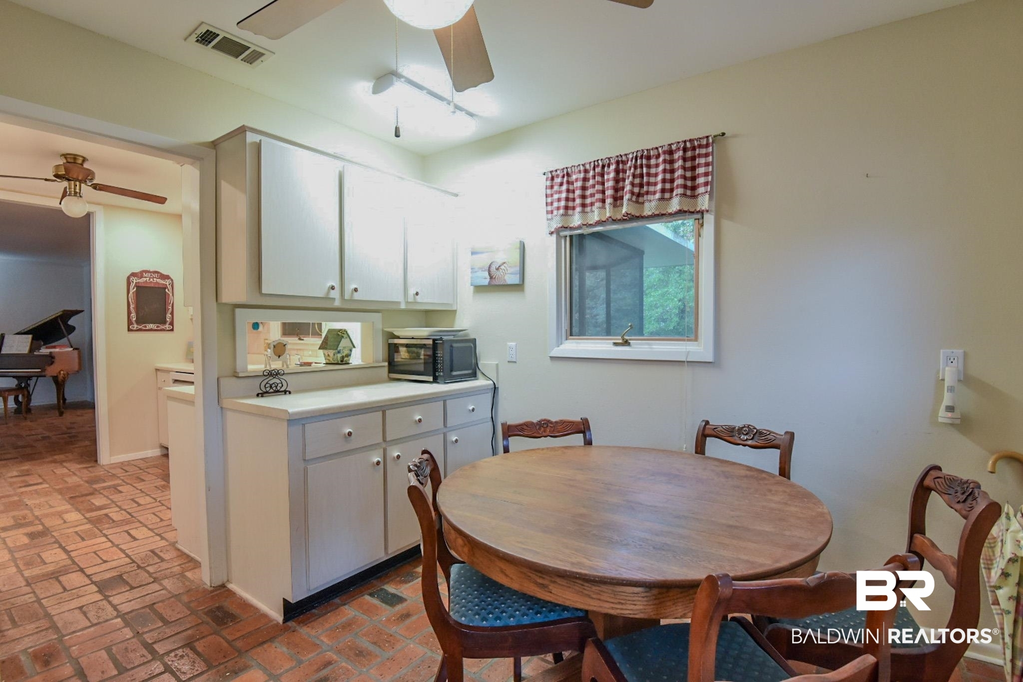 90 Paddock Drive Fairhope, AL 36532 - Photo 11 of 23 Kitchen with light countertops, ceiling fan, white cabinets, brick floors, and black microwave