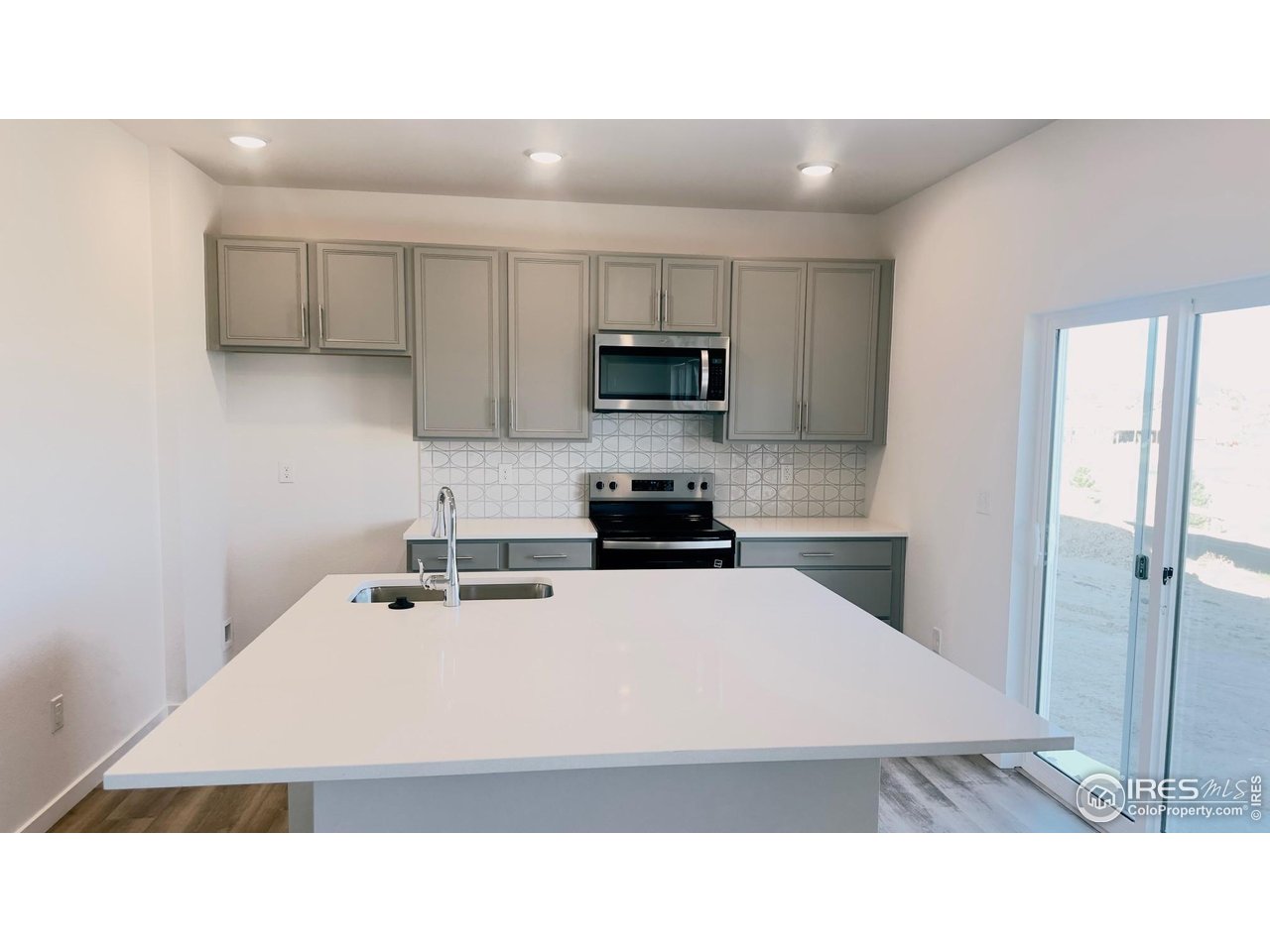 677 Muturu Road Johnstown, CO 80534 - Photo 3 of 11 a kitchen with a sink a stove top oven and white cabinets