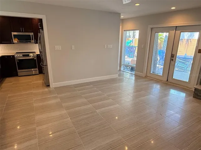 a view of an empty room with wooden floor and a fireplace