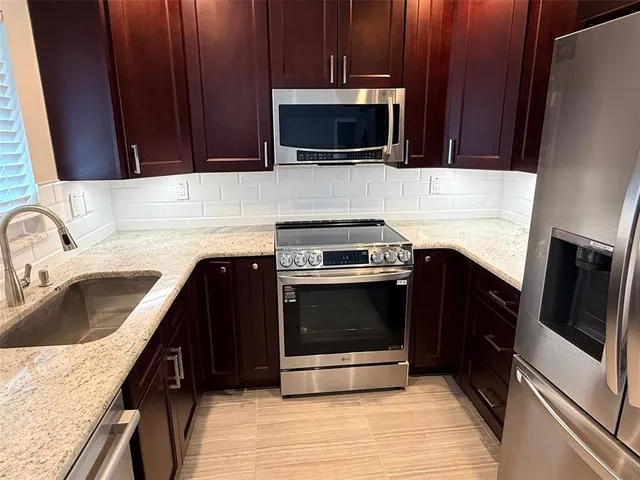 a kitchen with a sink stove and microwave