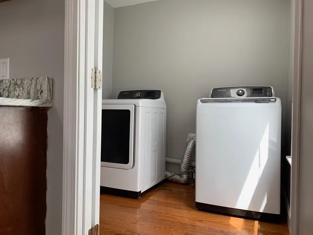 a utility room with wooden floor washer and dryer