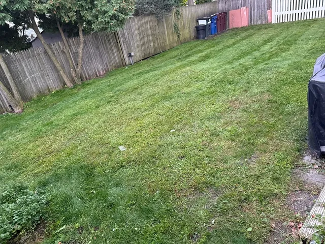 a view of a backyard with a small cabin and wooden fence